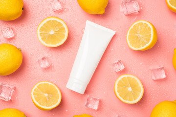 Top view photo of white tube without label in the middle ice cubes water drops halves and whole yellow lemons on isolated pastel pink background with copyspace
