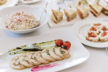 Table setting for a banquet or celebration. Empty wine glasses for spirits, champagne and juice. Set the table. Cloth napkins on a platter. Banqueting hall. Cold appetizers and salads