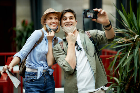 Happy tourist couple taking selfie and having fun on vacation during COVID-19 pandemic.