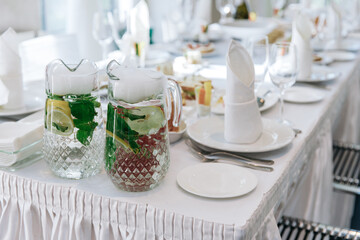 Table setting for a banquet or celebration. Empty wine glasses for spirits, champagne and juice. Set the table. Cloth napkins on a platter. Banqueting hall. Cold appetizers and salads