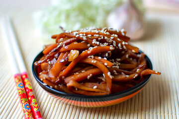 Kinpira carrots with sesame seeds, Japanese side dish, styled with chopsticks and hydrangea