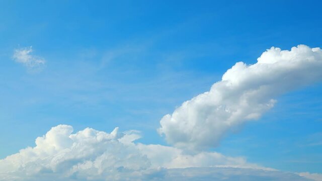 Time-lapse of rolling white cumulus clouds in blue sky