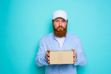 Courier with hat is unhappy to deliver a carton box