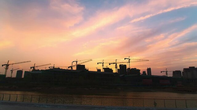Time-lapse of cranes in building construction at dusk