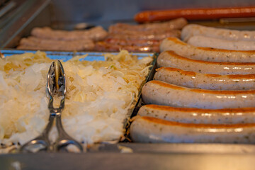 Frying pork sausages with fried sauerkraut at fast food restaurant.
