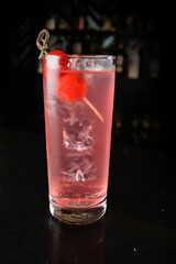 bartender special cold pink fruit punch cocktail wine or mocktail with cherry pop juice in tall glass goblet on black background luxury hotel pub iced beverage menu