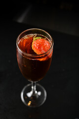 bartender special cold red wine cocktail or mocktail fruit juice with strawberry in tall glass goblet on black background luxury hotel pub iced beverage menu