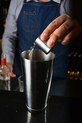 Fototapeta na wymiar bartender make special cold cocktail or mocktail in tall glass goblet on black background luxury hotel pub iced beverage menu