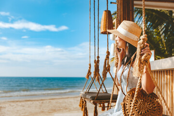 Traveler asian woman travel and relax on swing in beach cafe at Koh chang summer Thailand