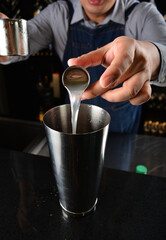 bartender make special cold cocktail or mocktail in tall glass goblet on black background luxury hotel pub iced beverage menu