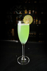 bartender special cold green lime cocktail or mocktail fruit juice with lime in tall glass goblet on black background luxury hotel pub iced beverage menu