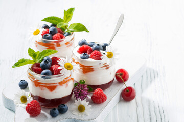 sweet dessert with jam, cream and fresh fruit on white background, top view