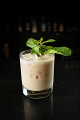 bartender special cold almond milk cocktail with mint leaf or mocktail juice in tall glass goblet on black background luxury hotel pub iced beverage menu