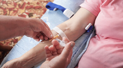 Doctor inputs liquid medicine by syringe to catheter in vein.