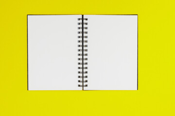 Fototapeta na wymiar Blank spiral notebook on yellow background. Top view with copy space for input the text.