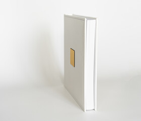 white book in leather binding with a gold metal insert for inscription.