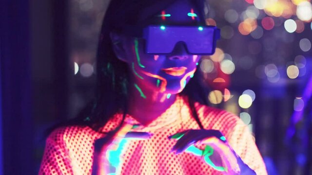 Neon  asian woman dancing. Fashion model woman in neon light, portrait of beautiful model with fluorescent make-up, Art and future design of female disco dancer posing in UV, colorful make up.