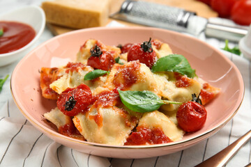 Tasty ravioli with tomato sauce served on table, closeup