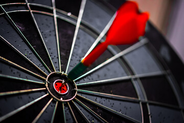 Close up shot of the dart arrow hit on bulleyes of dartboard to represent that the business reached...
