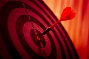 Close up shot of the dart arrow hit on bulleyes of dartboard to represent that the business reached...