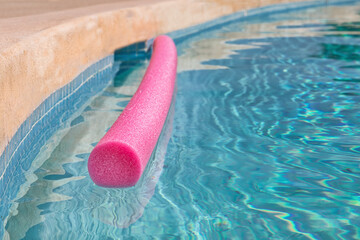 Swimming Pool with Float. Closeup. Focus in the front. Isolated. Pink floating snake with abstract water ripples. Stock Image.