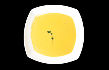 Delicious pumpkin cream soup in a square bowl top view isolate on white background