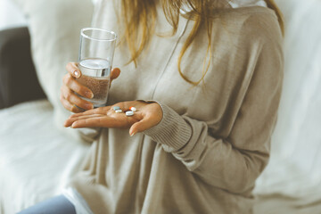 Close-up woman holding pills time to take medications, cure for headache, high blood pressure or...