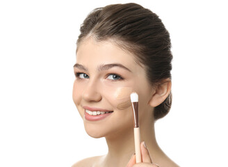 Beautiful girl applying foundation with brush on white background. Face contouring