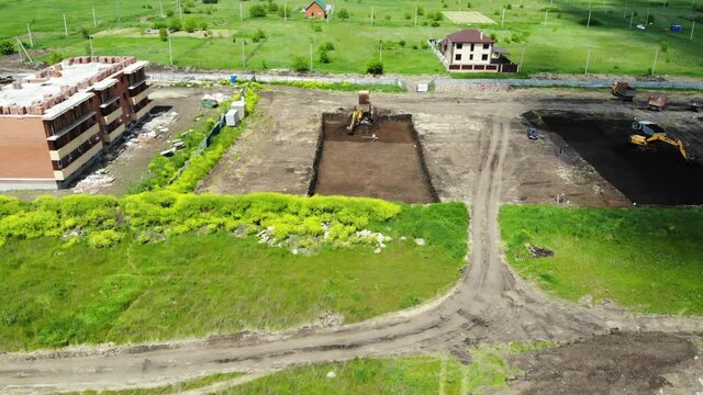 The work of special machines. The work of special vehicles. Tractor digs a pit. Excavator digs a pit. Work machinery on the construction site. Excavator digs a pit.