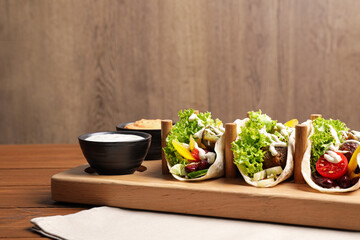 Delicious fresh vegan tacos served on wooden table. Space for text