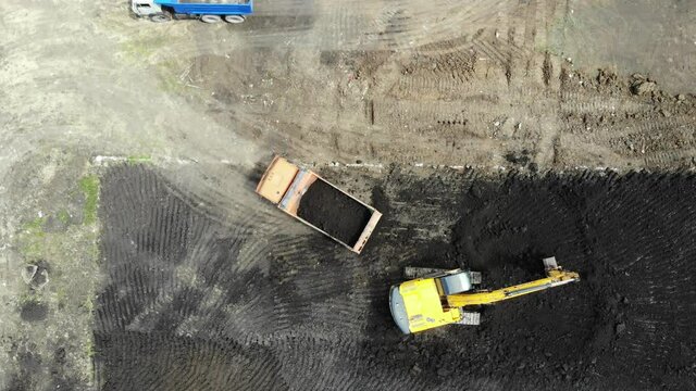 Aerial view of the construction site. Special machinery digs a pit. Work machinery. Machines digging pit. Construction process. Pit for building. Construction site from the air.