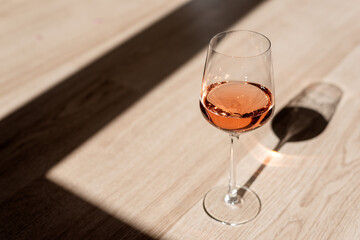 A glass of wine on a wooden background.