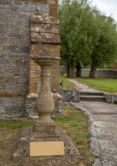 Fototapeta na wymiar Close and selective focus on a sun dial outside a small church in the Somerset countryside
