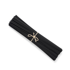 Raw black spaghetti pasta bunch isolated on white background. Dry black macaroni. Top view, flat lay.