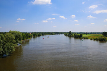 Panoramic view on typical dutch rural landscape with river maas and green agricultural fields in summer against blue sky near town Well, Limburg, Netherlands