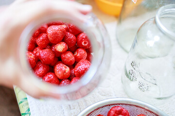 in a glass jar lies a strawberry, close-up
