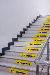 Perspective side view of calories burned stickers on staircase inside of office building in...