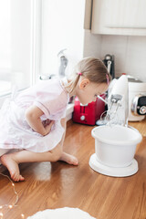 Obraz premium Children in the kitchen cook with their parents. Making homemade cake, pastries or cookies for the whole family. Happy childhood concept. Little twin sisters in kitchen aprons and chef hats