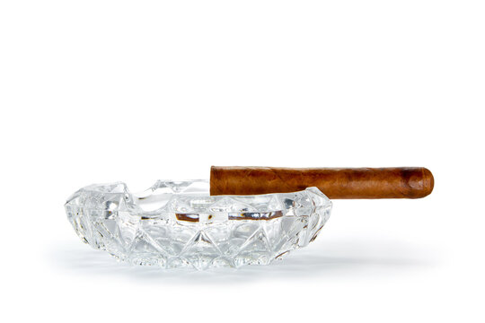 close up view of nice robusto Cuban cigar and ashtray on white back 