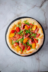 Prosciutto, arugula and cherry tomato pizza