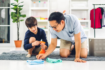 Obraz na płótnie Canvas Father teaching asian kid little boy son use disinfectant spray bottle cleaning and washing floor wiping dust with rags while cleaning house together at home
