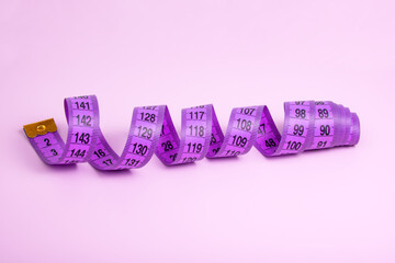 Bright purple tape measure on violet background with copyspace - obrazy, fototapety, plakaty