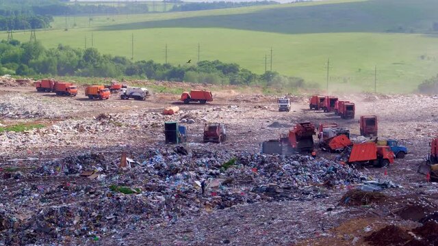 Garbage trucks of the landfill, view from the side. The facility for the placement of waste, the increase in landfill area. Burial of waste. High quality. 4k footage.