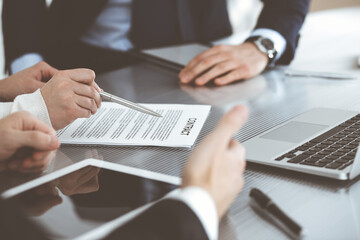 Business people discussing contract working together at meeting in modern office. Unknown businessman and woman with colleagues or lawyers at negotiation