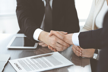 Business people shaking hands after contract signing in modern office. Teamwork, partnership and handshake concept