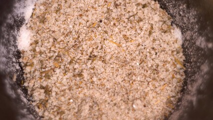 Edible salt. Sea salt. Seasoning for the dish. Spicy taste. Seasoning mix. White color. Dark cup. Rotation. View from above. Close-up.