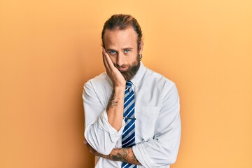 Handsome man with beard and long hair wearing business clothes thinking looking tired and bored with depression problems with crossed arms.