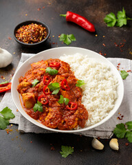 Spicy Chicken Pathia curry with basmati rice in a white plate. healthy food.