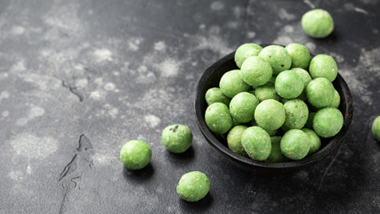 Spicy wasabi peanuts snack in black bowl