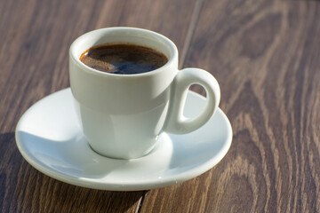 A cup of freshly brewed espresso coffee is on the table. Copy space.